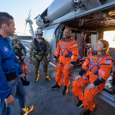 NASA astronaut Victor Glover, Artemis II pilot, left, and NASA astronaut Christina Koch, Artemis II mission specialist, talk with NASA...