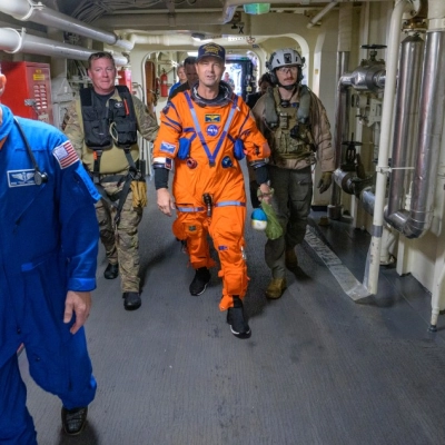 NASA astronaut Reid Wiseman, Artemis II commander is assisted off the flight deck after arriving aboard USS John P. Murtha...