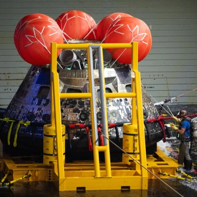 NASA’s Orion spacecraft is seen as members of agency’s Landing and Recovery team perform hazard checks after recovering the spacecraft...