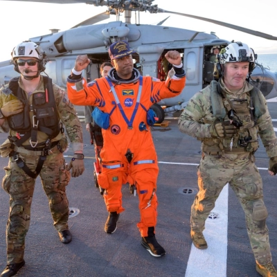 NASA astronaut Victor Glover, Artemis II pilot is assisted off the flight deck after arriving aboard USS John P. Murtha...