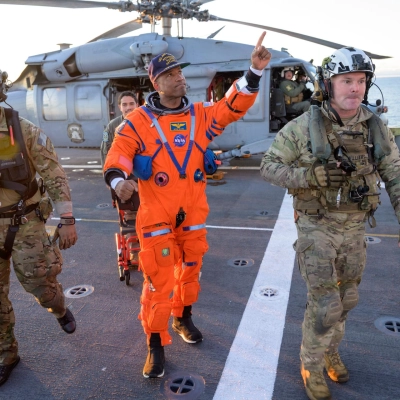 NASA astronaut Victor Glover, Artemis II pilot is assisted off the flight deck after arriving aboard USS John P. Murtha...