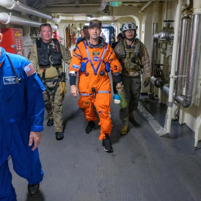 NASA astronaut Reid Wiseman, Artemis II commander is assisted off the flight deck after arriving aboard USS John P. Murtha...