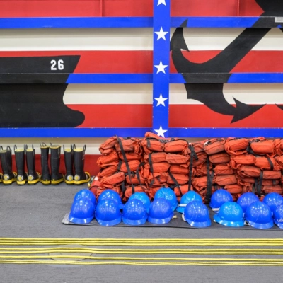 Life jackets, helmets, throw ropes, and boots are seen laid out onboard USS John P. Murtha as NASA, U.S. Navy.,...