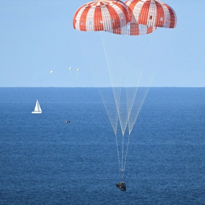PHOTO DATE: April 10, 2026.LOCATION: Off the coast of California. SUBJECT: NASA’s Orion capsule descends under its main parachutes over...