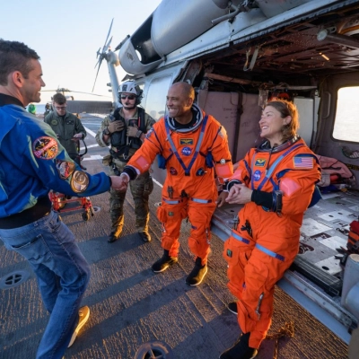 NASA astronaut Victor Glover, Artemis II pilot, left, and NASA astronaut Christina Koch, Artemis II mission specialist, talk with NASA...