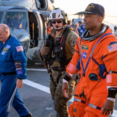 NASA astronaut Victor Glover, Artemis II pilot is assisted off the flight deck after arriving aboard USS John P. Murtha...