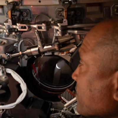 art002e009273 (April 6, 2026) - Artemis II pilot and NASA astronaut Victor Glover peers out one of the Orion spacecraft's...