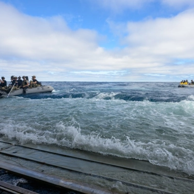 U.S. Navy divers deploy in small boats from the well deck of USS John P. Murtha to recover Artemis II...