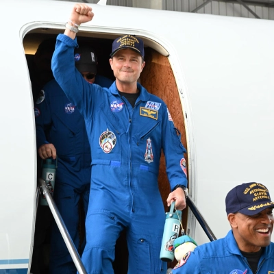 jsc2026e022276 (April 11, 2026) - Artemis II Commander Reid Wiseman returns home to Houston, stepping off a plane at Ellington...